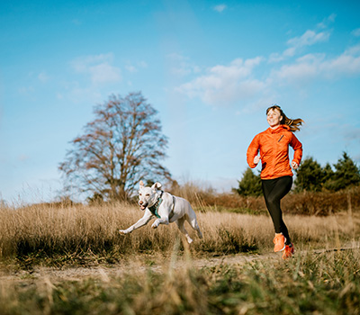 Eine Frau läuft mit Ihren Hund